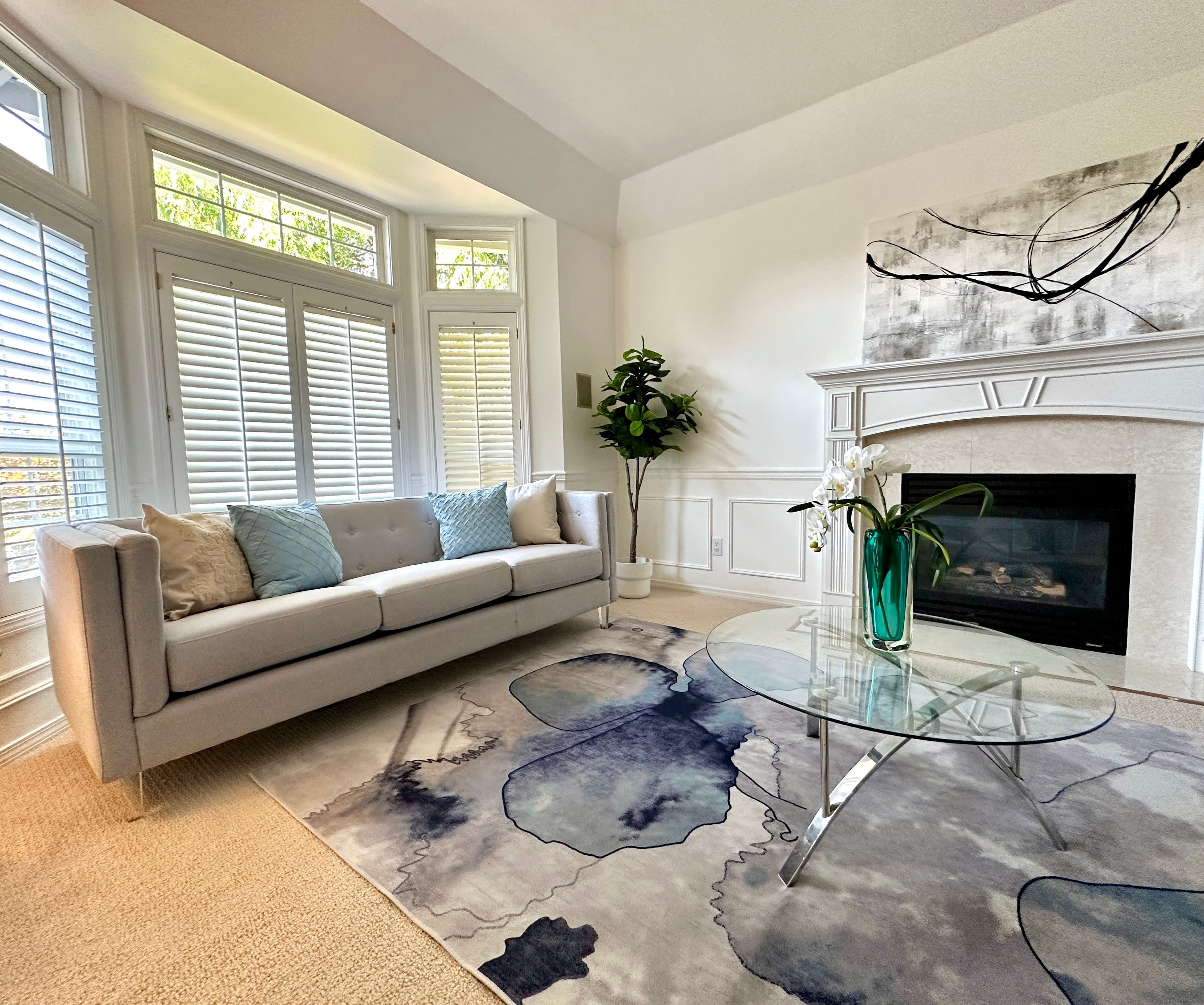 Living Room — Gray Sofa Close-Up with Blue Abstract Art & Glass Coffee Table