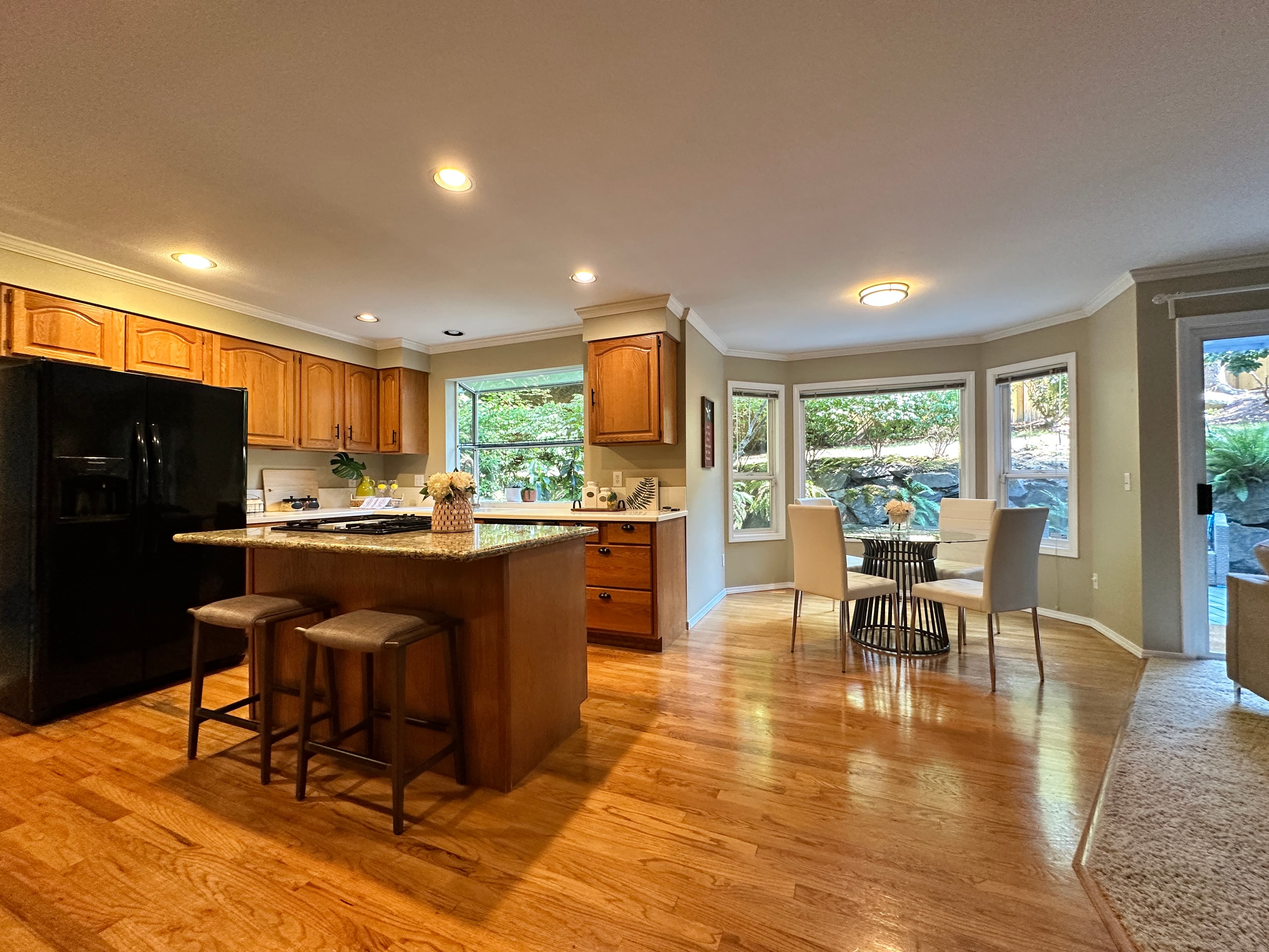 Kitchen — Warm Wood Cabinets, Island with Barstools & Bay Window Breakfast Nook