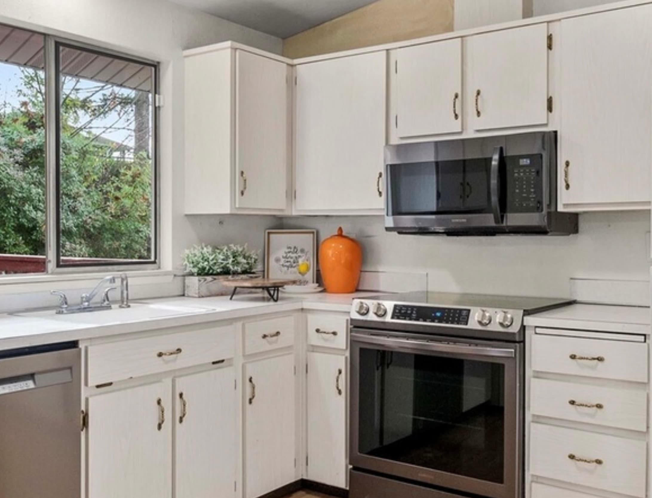 Kitchen — White Cabinets, Stainless Steel Range & Orange Ceramic Vase