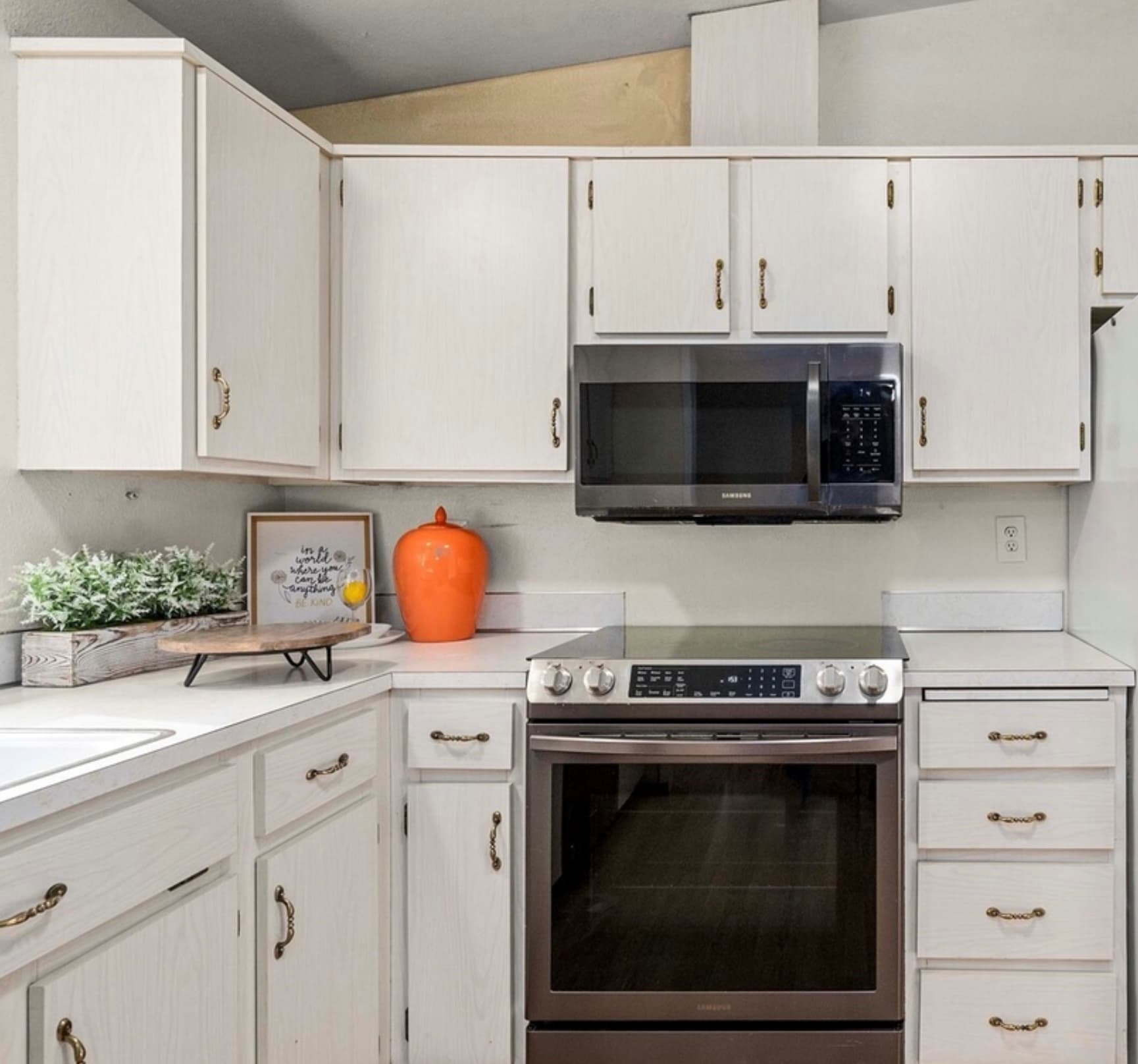 Kitchen — Range & Microwave Area with Orange Vase & Herb Greenery
