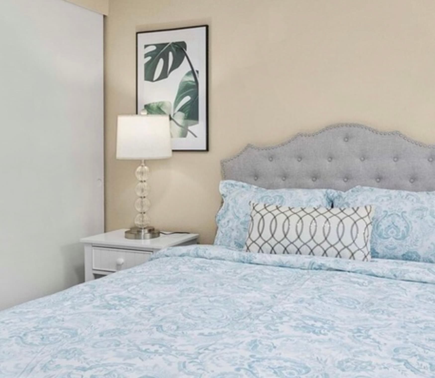 Guest Bedroom — Tufted Headboard Close-Up with Blue Damask & Monstera Art